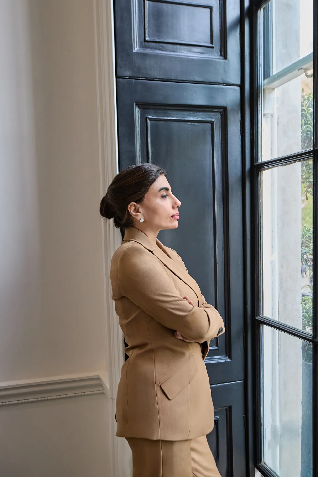 Amna Zaidi looking out of a tall window